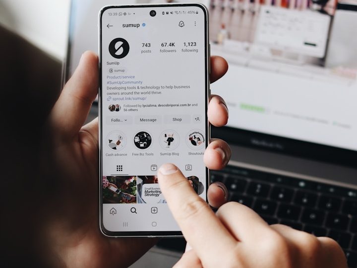 Person hält ein Smartphone mit Social Media Feed zur Veranschaulichung der digitalen Präsenz.